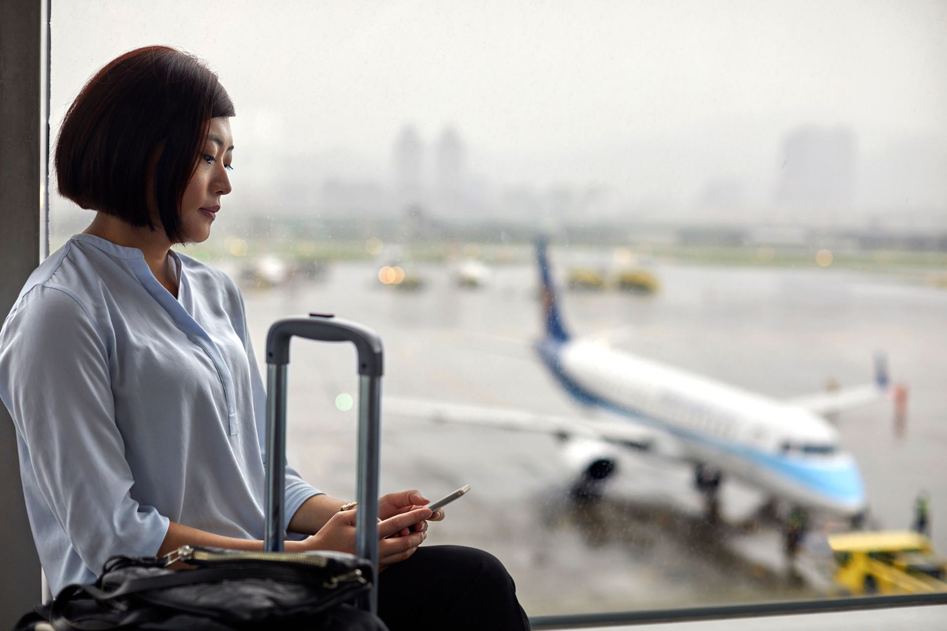 Femme d’affaires utilisant le téléphone mobile dans la salle d’attente