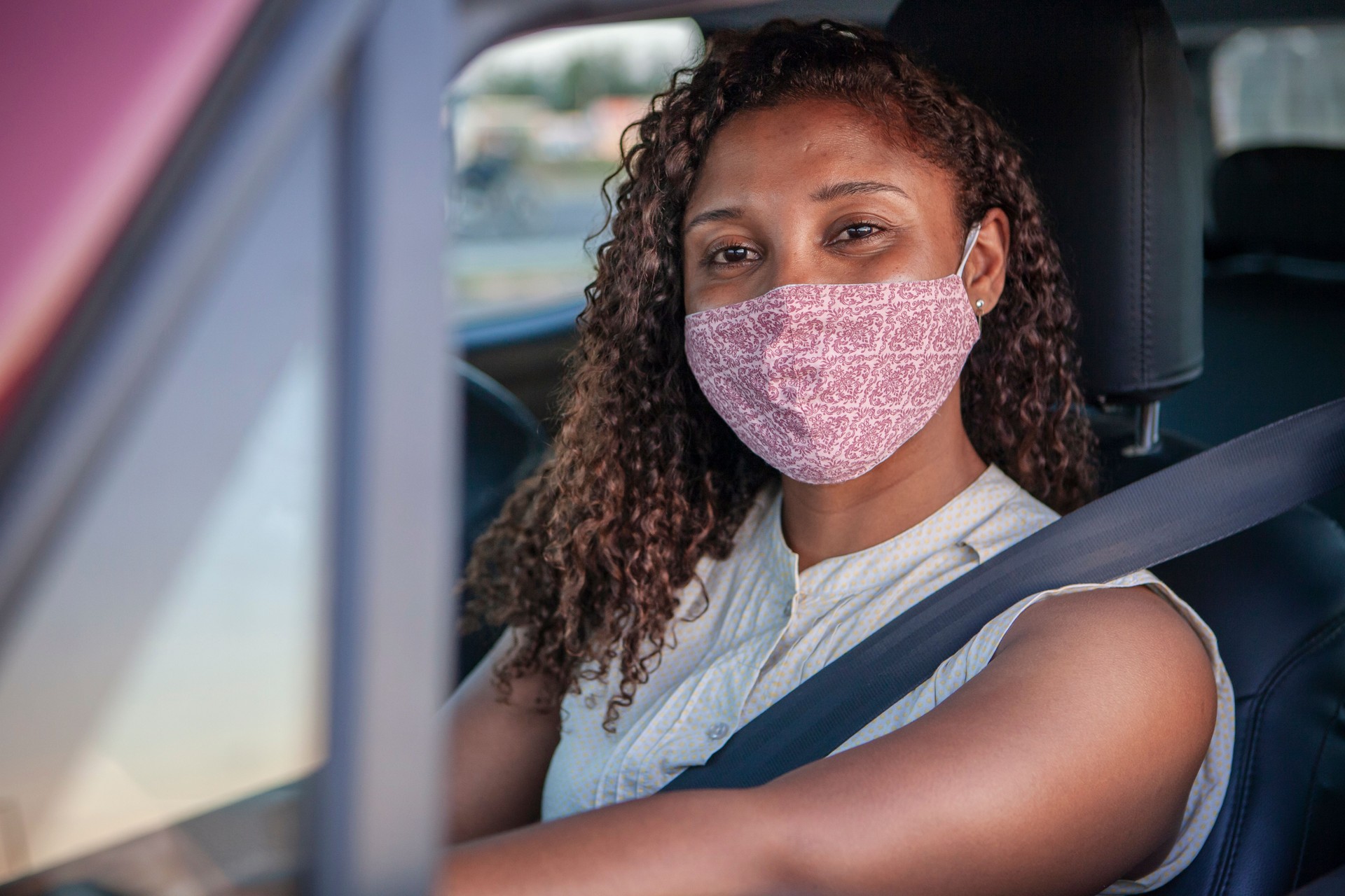 Femme noir conduisant et souriant derrière le masque. Nouveau concept normal.